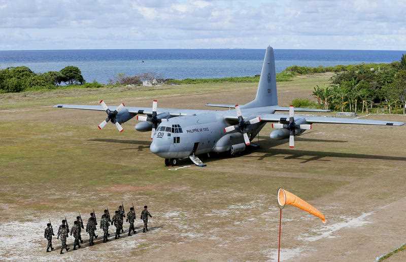 A file photo shows a Philippine Air Force C-130 transport plane as Philippine troops march at the Philippine-claimed Thitu Island off the disputed Spratlys chain of islands in the South China Sea in western Philippines.