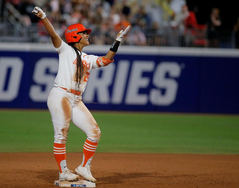 Oklahoma State's Morgyn Wynne (26) celebrates a double in the second inning during a softball game between Oklahoma State and Utah in the Women's College World Series at USA Softball Hall of Fame Stadium in  in Oklahoma City, Friday, June, 2, 2023. 