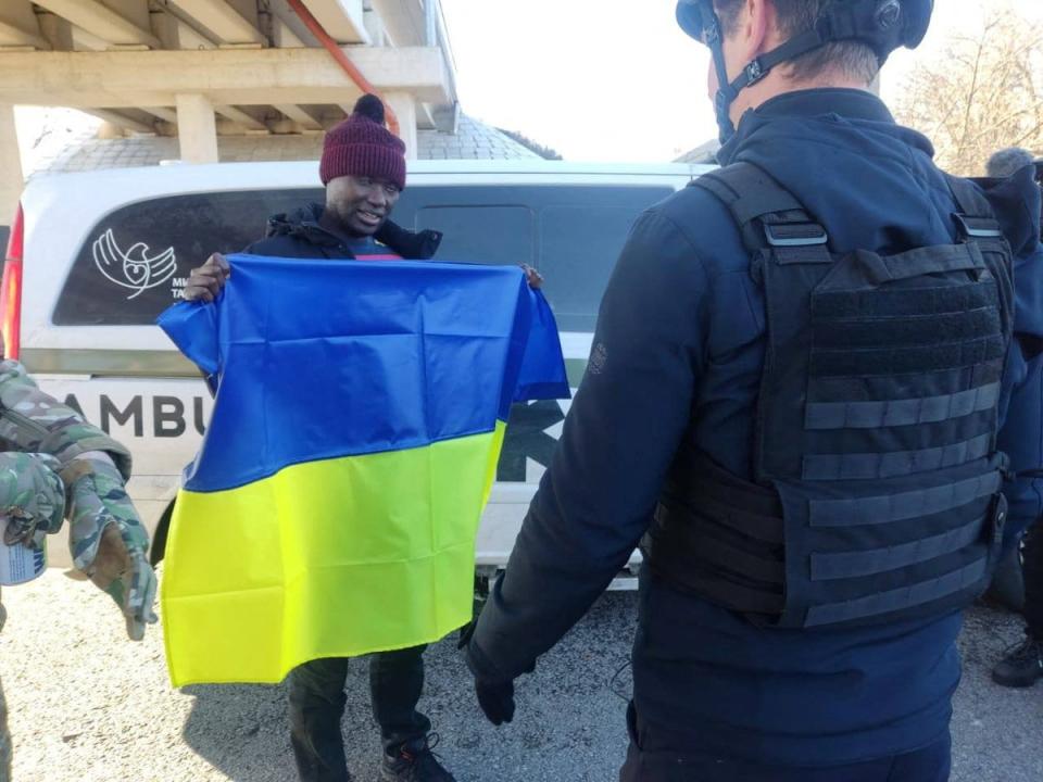 US citizen Suedi Murekezi holds a Ukrainian national flag after a prisoners-of-war swap (via REUTERS)