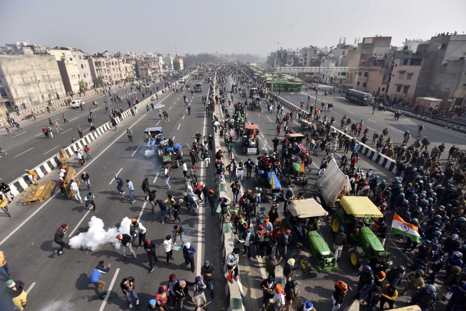 NEW DELHI, INDIA - JANUARY 26: Demonstrators in large numbers at NH-24 during the farmers' tractor rally on Republic Day, on January 26, 2021 in New Delhi, India. Major scenes of chaos and mayhem at Delhi borders as groups of farmers allegedly broke barricades and police check posts and entered the national capital before permitted timings. Police used tear gas at Delhi's Mukarba Chowk to bring the groups under control. Clashes were also reported at ITO, Akshardham. Several rounds of talks between the government and protesting farmers have failed to resolve the impasse over the three farm laws. The kisan bodies, which have been protesting in the national capital for almost two months, demanding the repeal of three contentious farm laws have remained firm on their decision to hold a tractor rally on the occasion of Republic Day.(Photo by Sanjeev Verma/Hindustan Times via Getty Images)