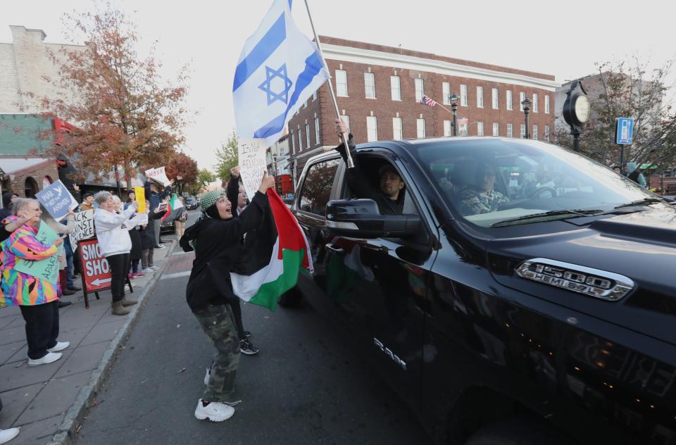 Protester with a Palestinian flag yells at the occupants of a truck with an Israeli flag during a protest in Nyack, N.Y., on Nov. 10, 2023, calling for a cease-fire in the Israel-Hamas war. The truck kept circling the block, passing by the protest.