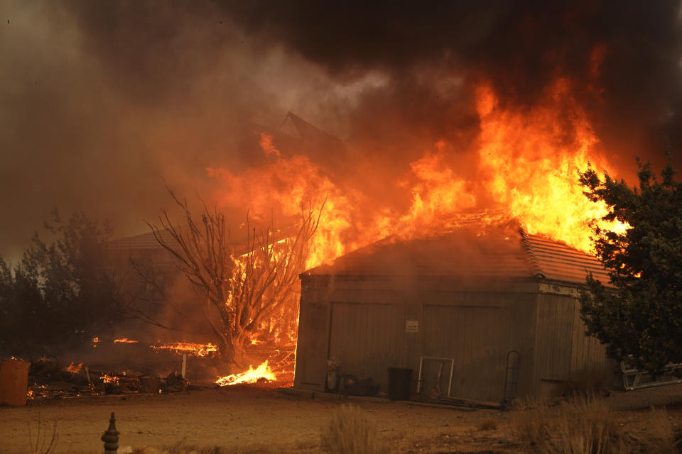 A home burns along Cima Mesa Rd. as the Bobcat Fire advances Friday, Sept. 18, 2020, in Juniper Hills, Calif. (AP Photo/Marcio Jose Sanchez)