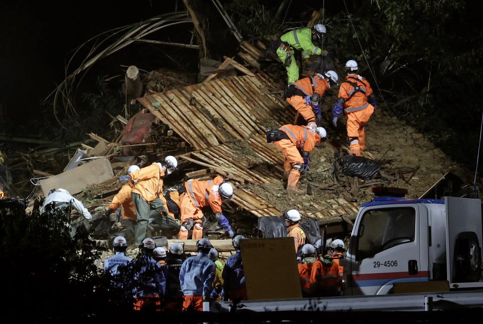 Rescue workers continue to search for missing residents amid the ruins of a house in Gamagori, Aichi Prefecture (EPA)