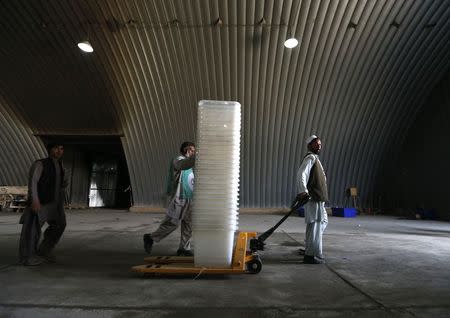 Afghan election commission workers move ballot boxes and election material in a warehouse in Kabul June 13, 2014. The second round of Afghanistan's presidential election will take place on June 14. REUTERS/Mohammad Ismail