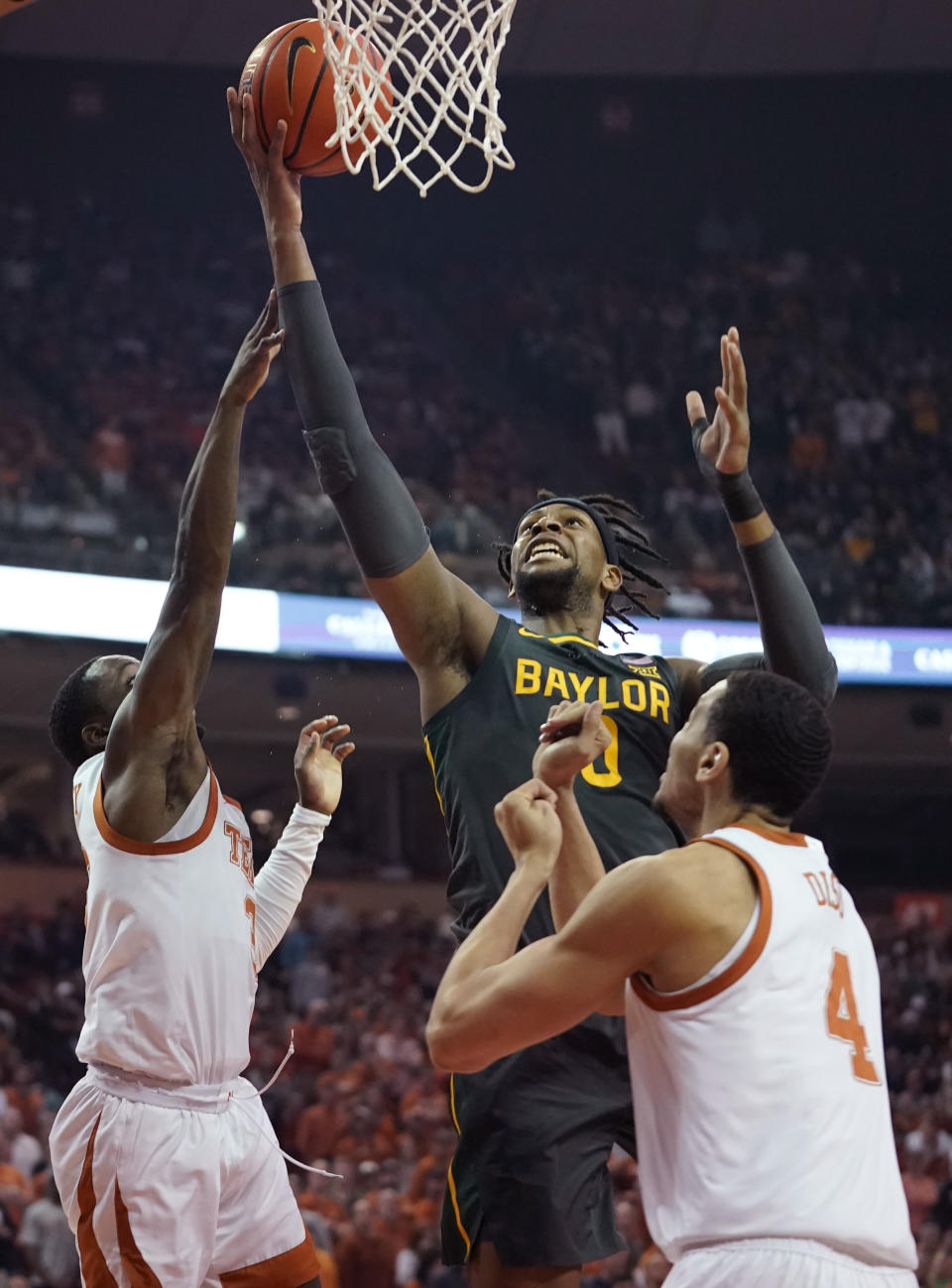 Baylor forward Flo Thamba (0) scores past Texas guard Courtney Ramey (3) and forward Dylan Disu (4) during the first half of an NCAA college basketball game Monday, Feb. 28, 2022, in Austin, Texas. (AP Photo/Eric Gay)