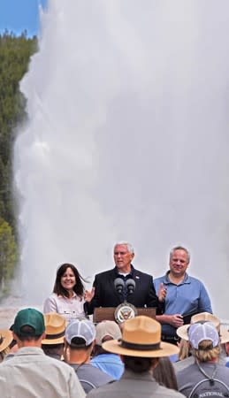 U.S. Vice President Mike Pence, flanked by wife Karen and Interior Secretary David Bernhardt, speaks in front of Old Faithful Geyser in Yellowstone National Park