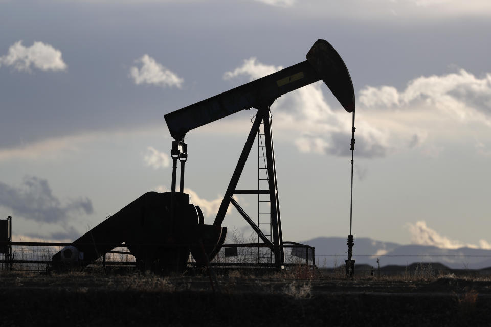 FILE--In this Saturday, Dec. 22, 2018, file photograph, a pump jack is shown over an oil well along Interstate 25 near Dacono, Colo. traffic flows on Interstate 25 into downtown Denver. (AP Photo/David Zalubowski)
