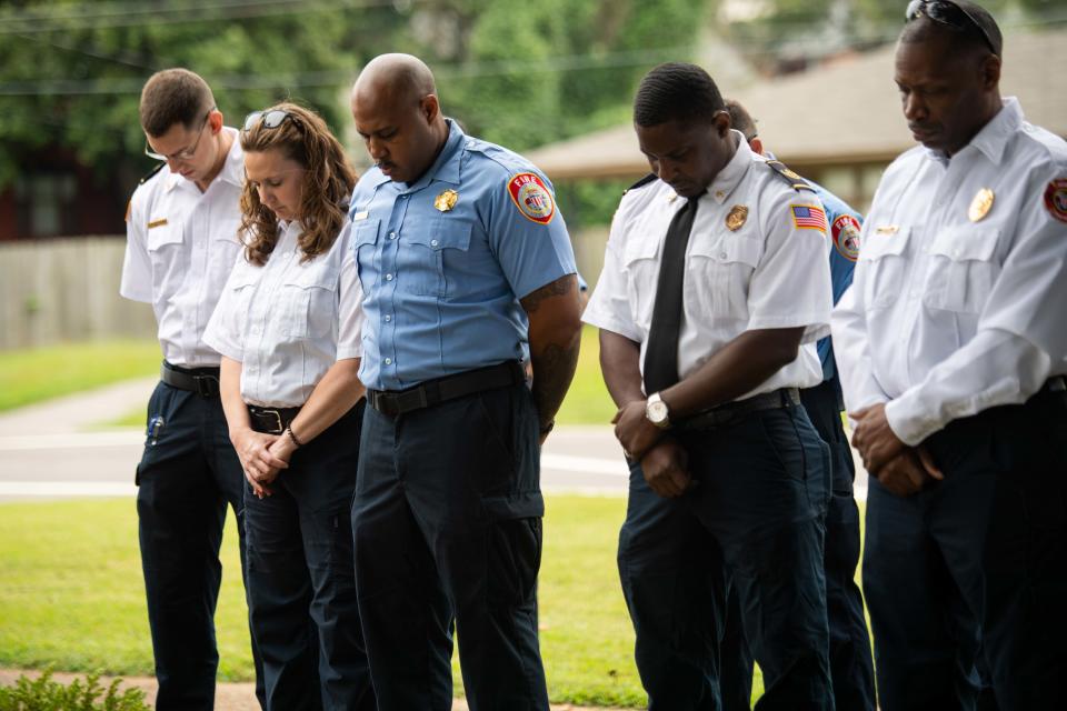 Jackson Fire Department Firefighters bow their heads as Paster Adam Dooley leads prayer during the unveiling of the Safe Haven Baby Box at Jackson Fire Department Station 2 in Jackson, Tenn. on Sept. 13, 2023.