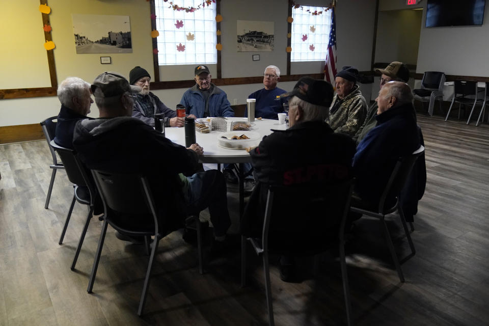 Earl Meyer, middle left, who fought for the U.S. Army in the Korean War, talks with fellow veterans at the American Legion, Tuesday, Nov. 7, 2023, in St. Peter, Minn. Meyer, 96, is suing the Army to try to get the Purple Heart medal that he says he earned when he was wounded during fierce combat in June of 1951. (AP Photo/Abbie Parr)