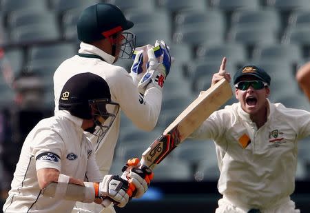 Australia's captain Steve Smith (R) celebrates as wicketkeeper Peter Nevill catches New Zealand's Tom Latham (L) for 50 runs during the first day of the third cricket test match at the Adelaide Oval, in South Australia, November 27, 2015. REUTERS/David Gray