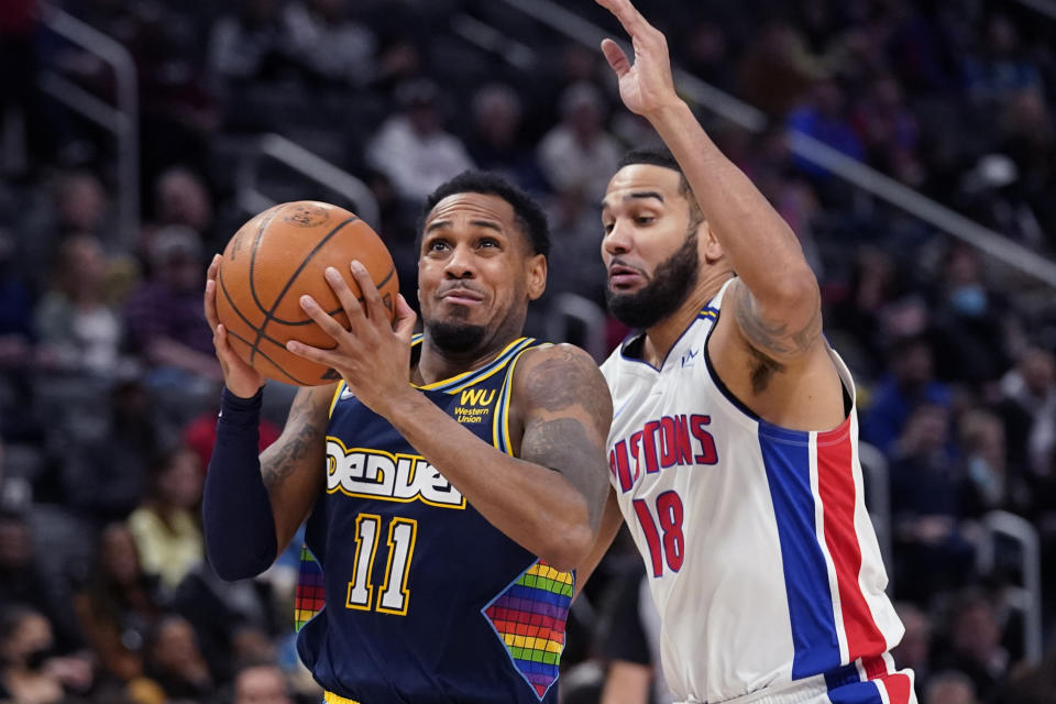 Denver Nuggets guard Monte Morris (11) drives to the basket as Detroit Pistons guard Cory Joseph (18) defends during the first half of an NBA basketball game, Tuesday, Jan. 25, 2022, in Detroit. (AP Photo/Carlos Osorio)