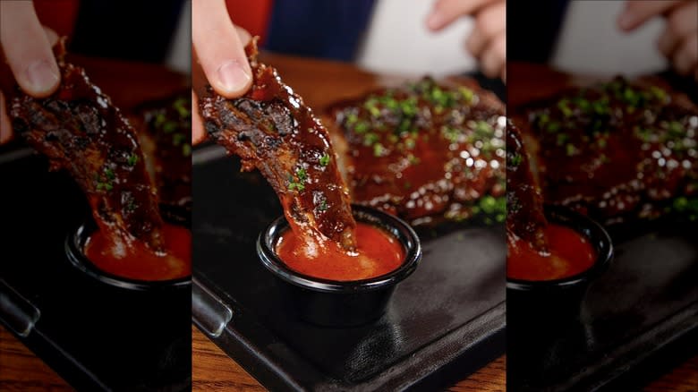 Rib dipped into sauce