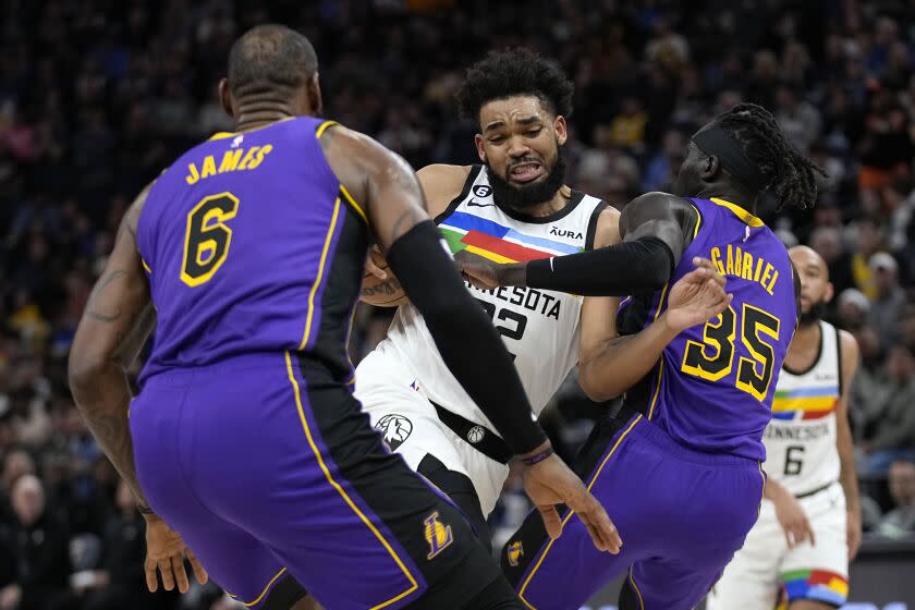 Minnesota Timberwolves center Karl-Anthony Towns works toward the basket while defended.