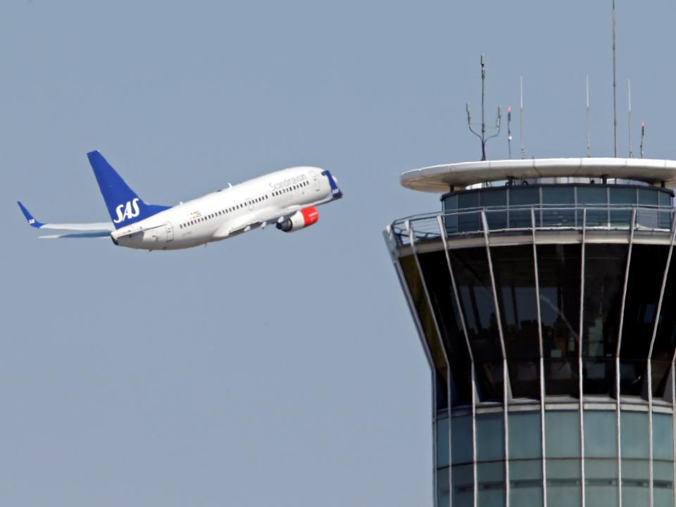 FILE PHOTO: A Scandinavian SAS airline passenger plane flies near the air traffic control tower after taking off from Charles de Gaulle International Airport in Roissy, near Paris, August 21, 2013.   REUTERS/Charles Platiau/File Photo
