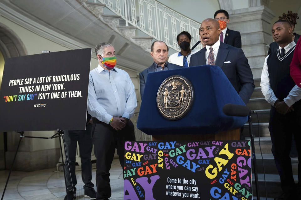 FILE — New York Mayor Eric Adams, at podium, addresses a news conference in the rotunda of City Hall, in New York, Monday, April 4, 2022. New York City is launching a digital billboard campaign, supporting LGBTQ visibility that will be displayed in five major markets in Florida for eight weeks, to lure Floridians unhappy with their state's "Don't Say Gay" law to the Big Apple, Adams announced. (Ed Reed/Office of the New York City Mayor via AP, File)