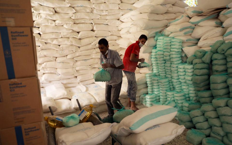 Workers prepare foodstuff for beneficiaries at a food distribution center supported by the World Food Program in Sanaa - Khaled Abdullah/Reuters