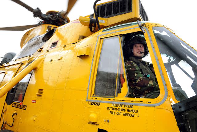 <p>JOHN STILLWELL/AFP via Getty</p> Prince William controls a Sea King helicopter during an exercise at Holyhead Mountain on March 31, 2011.