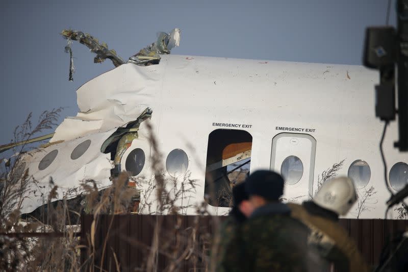 Emergency and security personnel are seen at the site of a plane crash near Almaty