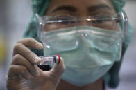 A lab technician holds a bottle containing results for COVID-19 vaccine testing at the National Primate Research Center, run by Chulalongkorn University in Saraburi Province, north of Bangkok, Saturday, May 23, 2020. Thai health officials said that scientists in Thailand have had promising results in testing a COVID-19 vaccine candidate on mice, and have begun testing on monkeys. (AP Photo/Sakchai Lalit)