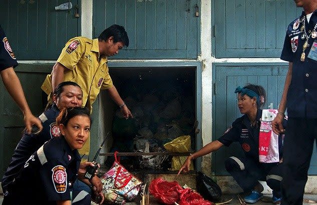 Police investigate the mortuary storage area of the temple