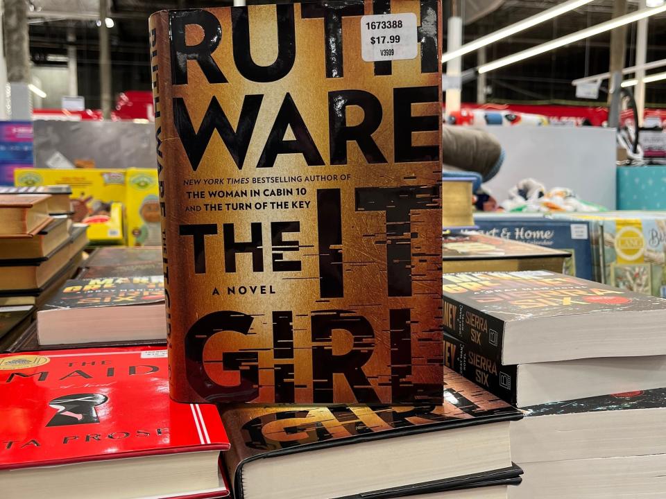 A brown book standing up among table of books at Costco