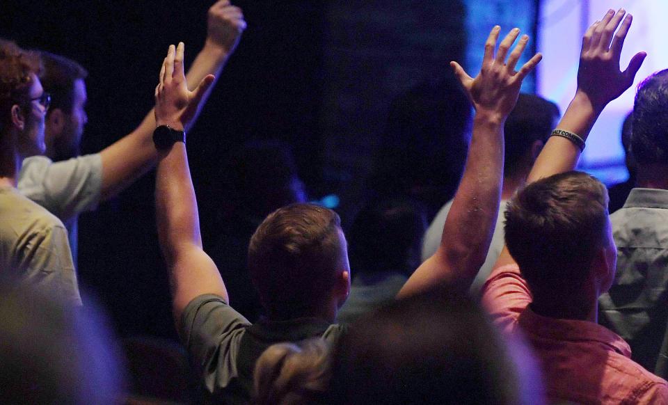 Members of Ames' Cornerstone Church pray during the first Sunday service after a June 2 shooting in the church's parking lot left three people dead.