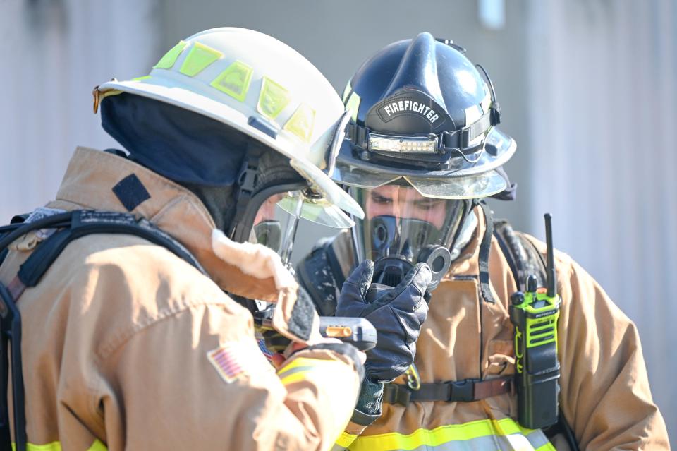 U.S. Air Force Staff Sgt. Chris Rowland, a crew chief with the 908th Civil Engineer Squadron, assists a crew member with their radio during a training exercise, August 5, 2022, at Maxwell Air Force Base, Alabama. Two-way radios equip firefighters with a way to communicate and have situational awareness.