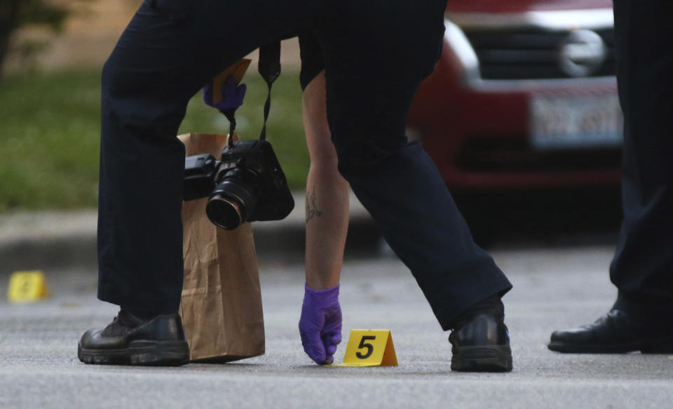 A police forensics services investigator picks up a bullet casing at the scene where a 3-year-old boy was fatally shot while riding in an SUV with his father, in the 5600 block of West Huron Street in the Austin neighborhood Saturday, June 20, 2020, in Chicago. Multiple people, including several children, were killed as more than 100 people were shot in a wave of gunfire in Chicago over the Father’s Day weekend that produced the city’s highest number of shooting victims in a single weekend this year. (John J. Kim/Chicago Tribune via AP)