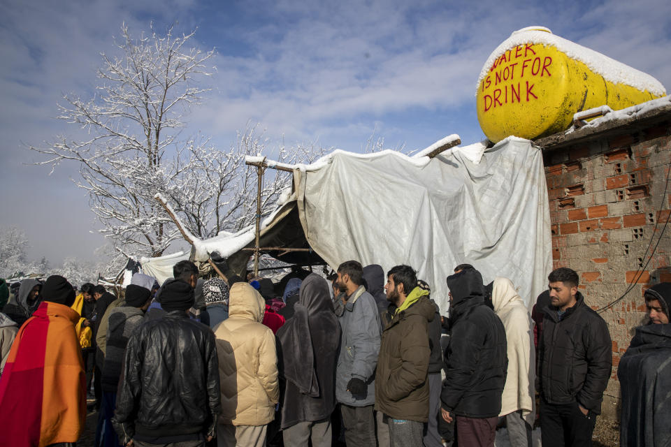 Migrants gather at the Vucjak refugee camp outside Bihac, northwestern Bosnia, Tuesday, Dec. 3, 2019. A European human rights official has demanded immediate closure of a migrant camp in Bosnia where hundreds of people have started refusing food and water to protest dismal living conditions as wintry weather sets in. (AP Photo/Darko Bandic)