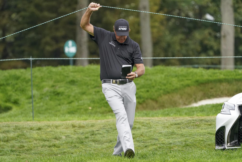 Phil Mickelson, of the United States, lifts a rope to cross over to the sixth tee during the first round of the US Open Golf Championship, Thursday, Sept. 17, 2020, in Mamaroneck, N.Y. (AP Photo/John Minchillo)