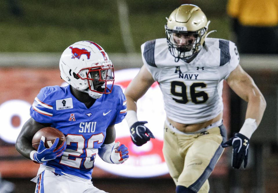 SMU running back Ulysses Bentley IV (26) carries the ball as Navy defensive tackle Jackson Perkins (96) defends during the first half of an NCAA college football game, Saturday, Oct. 31, 2020, in Dallas. (AP Photo/Brandon Wade)