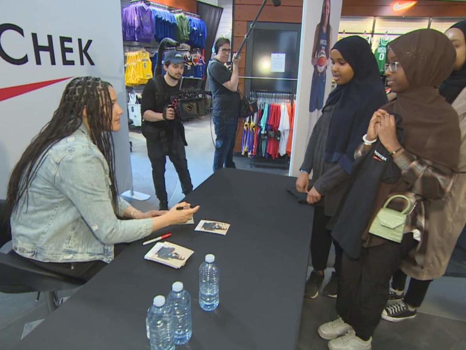 Minnesota Lynx forward player and Canadian native Natalie Achonwa meets and signs autographs for young fans. The team is squaring off against the Chicago Sky in the first Women's National Basketball League game in Canada and Toronto on Saturday. (Vedran Lesic/Radio-Canada - image credit)