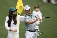 Emiliano Grillo, of Argentina, walks with Alexia Garcia Morris and son Andre, walk on the fifth hole during the par-3 contest at the Masters golf tournament at Augusta National Golf Club Wednesday, April 10, 2024, in Augusta, GA. (AP Photo/Charlie Riedel)