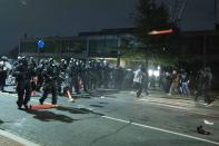 Washington Metropolitan Police Department police officers push back demonstrators outside of the fourth district police station in Washington, Wednesday, Oct. 28, 2020. Demonstrators gathered at the police station in protest over a fatal a crash involving a moped driver who died when he police were attempting to pull him over. The crash happened last Friday. (AP Photo/Jose Luis Magana)