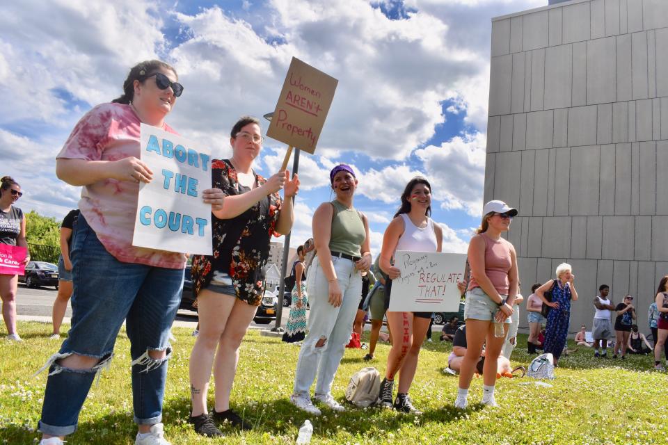 From left: Carlie Pierce of Endicott, Jenn Bradley of Sayre, Pennsylvania, Kaitlyn Worobey of Vestal, Gabby Rosas of Vestal, and Sara Miner of Vestal cheer as they listen to speakers at a demonstration Monday, June 27, in front of the Family Planning of South Central New York clinic on Hawley Street in Binghamton.