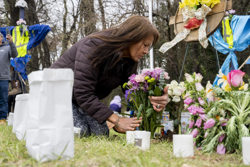 Elisa Salcedo lays flowers, Saturday, April 6, 2024, in front of the memorial site to honor the construction workers who lost their lives in the collapse of the Francis Scott Key Bridge, in Baltimore. (Kaitlin Newman/The Baltimore Banner via AP)