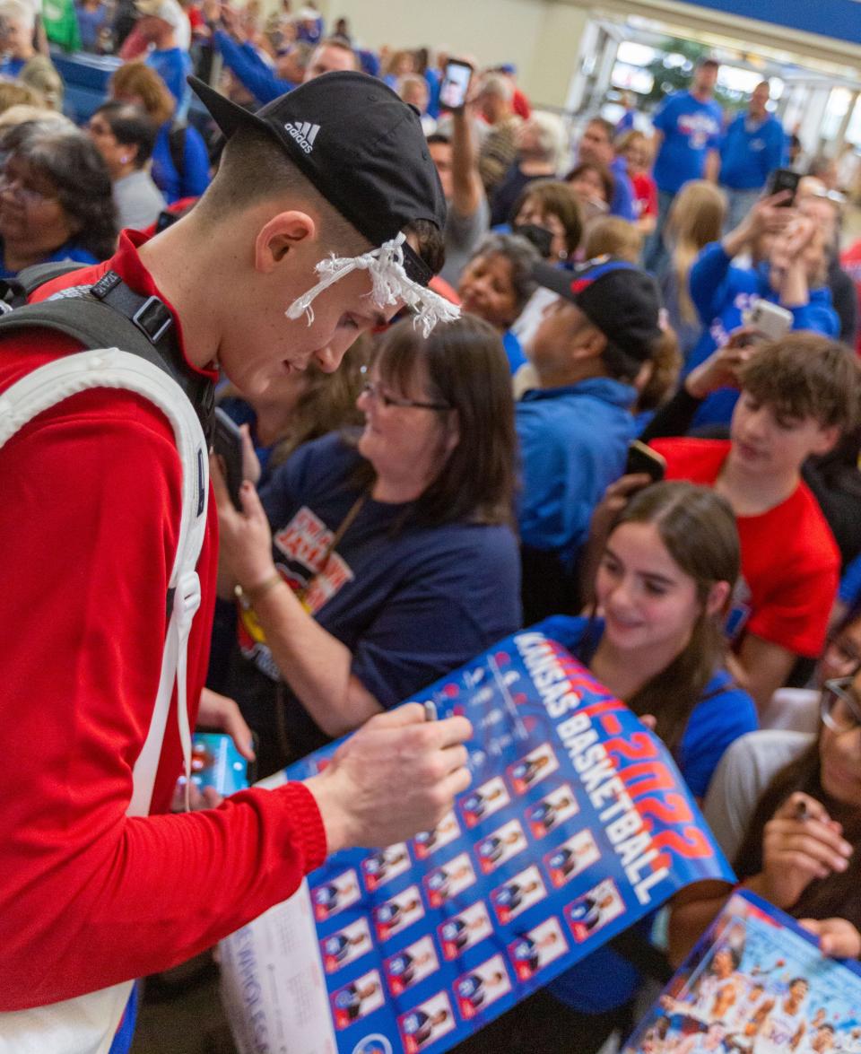 Kansas forward Mitch Lightfoot stops to talk with fans about the team's historic comeback to win the NCAA men's basketball championship inside the terminal at Topeka Regional Airport at Forbes Field on Tuesday, April 2, 2022.