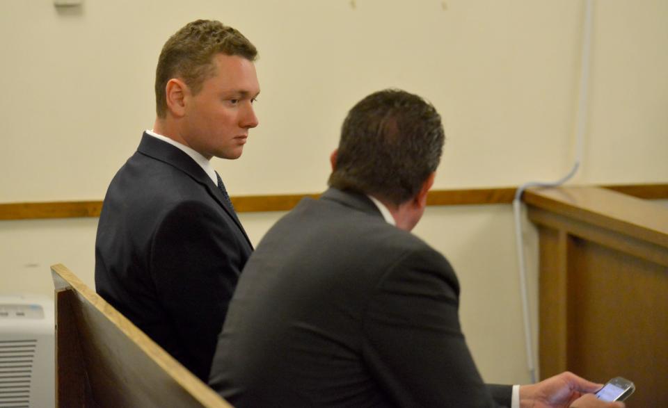 Reid Mason, left, talks with his attorney Peter Lloyd Tuesday in the courtroom of Barnstable District Court.