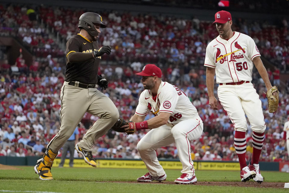 San Diego Padres' Victor Caratini, left, is tagged out by St. Louis Cardinals first baseman Paul Goldschmidt as Cardinals pitcher Adam Wainwright (50) watches during the third inning of a baseball game Saturday, Sept. 18, 2021, in St. Louis. (AP Photo/Jeff Roberson)