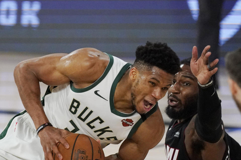 Milwaukee Bucks' Giannis Antetokounmpo, left, drives against Miami Heat's Jae Crowder, right, in the second half of an NBA conference semifinal playoff basketball game Friday, Sept. 4, 2020, in Lake Buena Vista, Fla. (AP Photo/Mark J. Terrill)