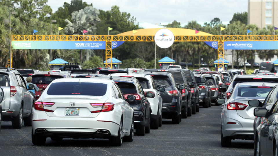 Cars line up to enter SeaWorld as it reopens, Thursday, June 11, 2020, in Orlando, Fla. The park had been closed since mid-March to stop the spread of the coronavirus. (AP Photo/John Raoux)