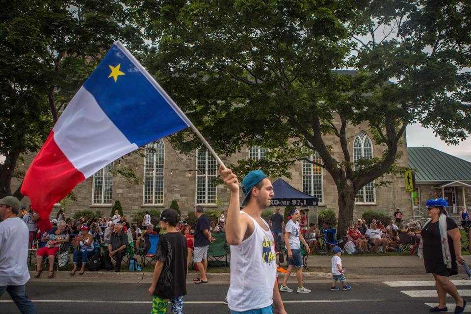 Acadians fill the streets of Caraquet, N.B., for the Tintamarre parade to commemorate National Acadian Day on Wednesday, Aug. 15, 2018.