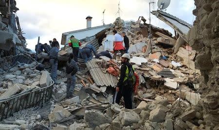 Rescuers work at a collapsed house following a quake in Amatrice, central Italy, August 24, 2016. REUTERS/Emiliano Grillotti