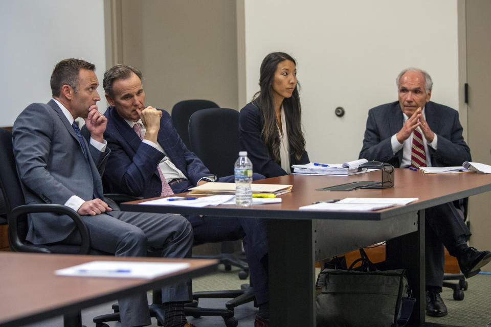 Defense attorneys, from left, Mark Dodge, Matthew Borgula, Mikayla S. Hamilton and David Dodge prepare for Grand Rapids police officer Christopher Schurr's arraignment at the Kent County Courthouse Friday, June 10, 2022 in Grand Rapids, Mich. A judge facing a packed courtroom set bond Friday at $100,000 for Schurr, a Michigan police officer charged with second-degree murder in the death of Patrick Lyoya, a Black man who was shot in the back of the head in April. (Daniel Shular/The Grand Rapids Press via AP)