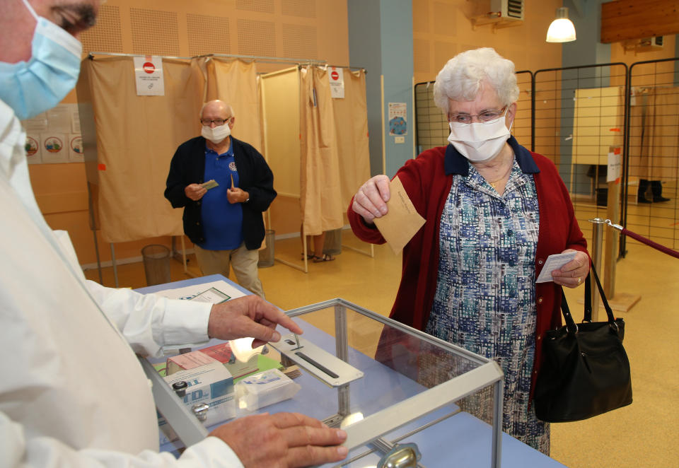 A woman casts a vote at a voting center during the second round of the municipal elections, in Saint Pee sur Nivelle, southwestern France, Sunday, 28, June, 2020. France is holding the second round of municipal elections in 5,000 towns and cities Sunday that were postponed due to the country's coronavirus outbreak. (AP Photo/Bob Edme)