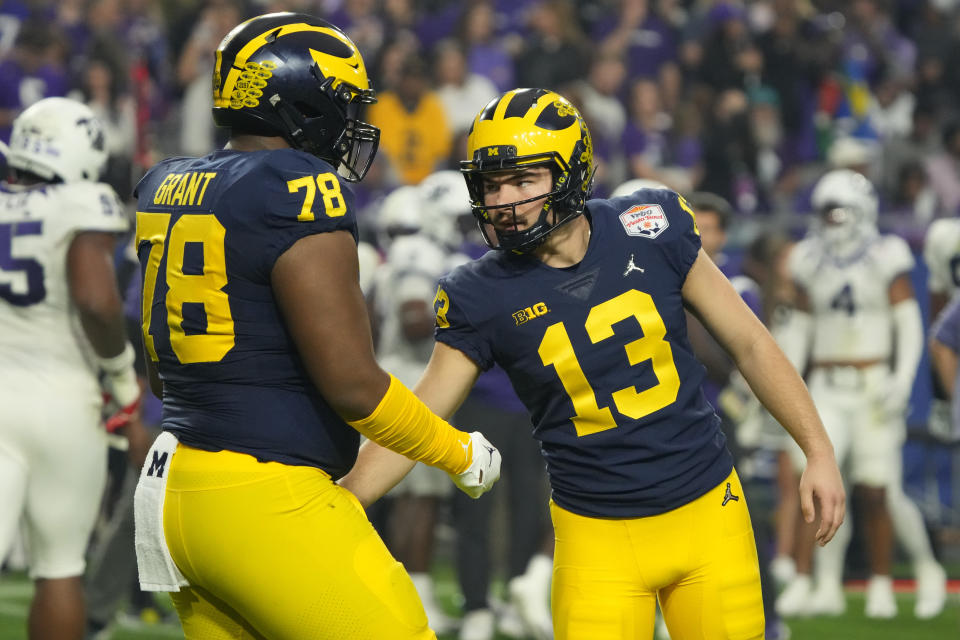 Michigan place kicker Jake Moody (13) celebrates his field goal with Michigan defensive lineman Kenneth Grant (78) during the second half of the Fiesta Bowl NCAA college football semifinal playoff game against TCU, Saturday, Dec. 31, 2022, in Glendale, Ariz. (AP Photo/Rick Scuteri)