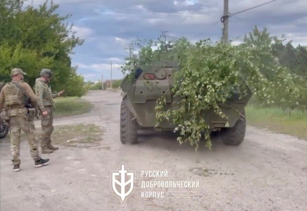 Fighters with the Russian forces stand next to an armoured vehicle in Vovchansk, Kharkiv Oblast (via REUTERS)