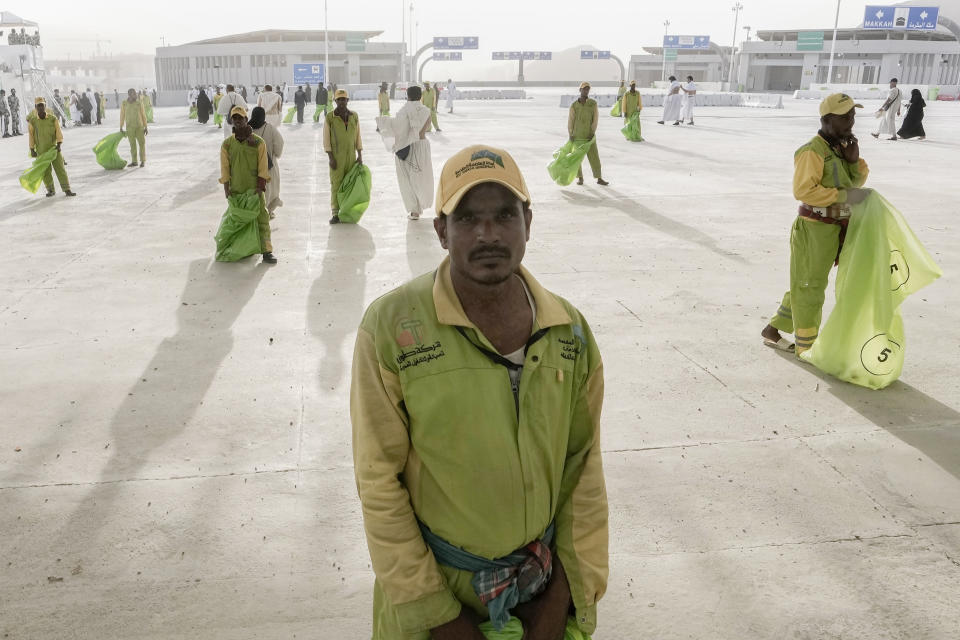 Cleaners line up in front of pilgrims after they cast stones at a pillar in the symbolic stoning of the devil, the last rite of the annual Hajj pilgrimage, in Mina near the holly city of Mecca, Saudi Arabia, Wednesday, June 28, 2023. It takes tens of thousands of cleaners, security personnel, medics and others to make the annual Hajj pilgrimage possible for 1.8 million faithful from around the world. (AP Photo/Amr Nabil)