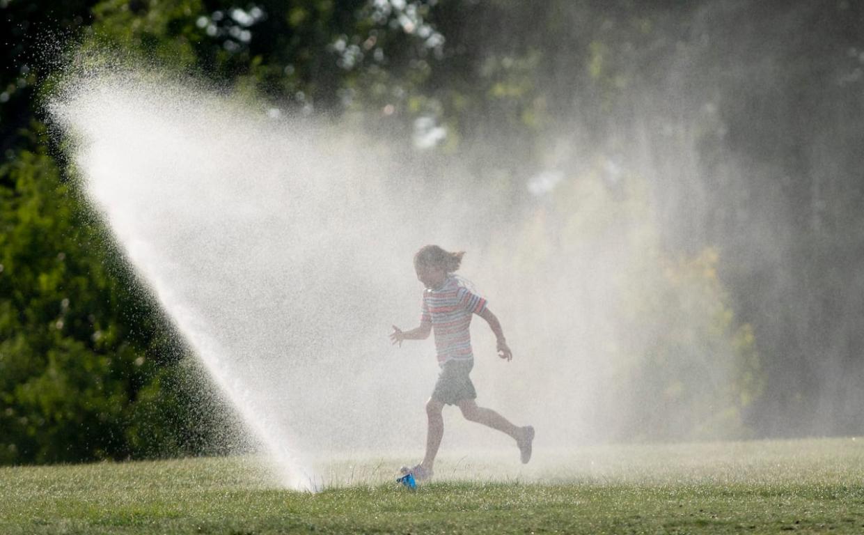 Unlike normal years, summer campers in Calgary can't beat the heat with water activities outdoors. That means running through sprinklers to cool down is off the table for now. (Adrian Wyld/Canadian Press - image credit)