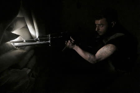 A rebel fighter takes position behind sandbags in Aleppo's Al-Ezaa neighborhood, Syria, May 20, 2015. REUTERS/Hosam Katan